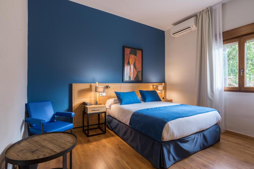 a bedroom with a bed and a blue wall at BYPILLOW California in Málaga