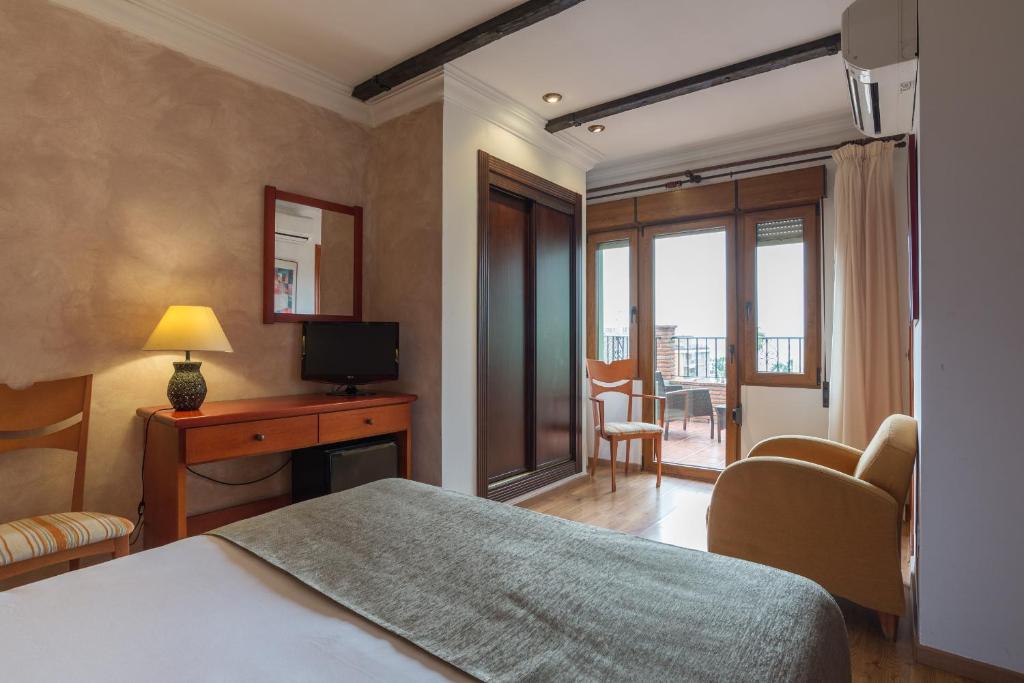 a hotel room with a bed and a television at BYPILLOW California in Málaga