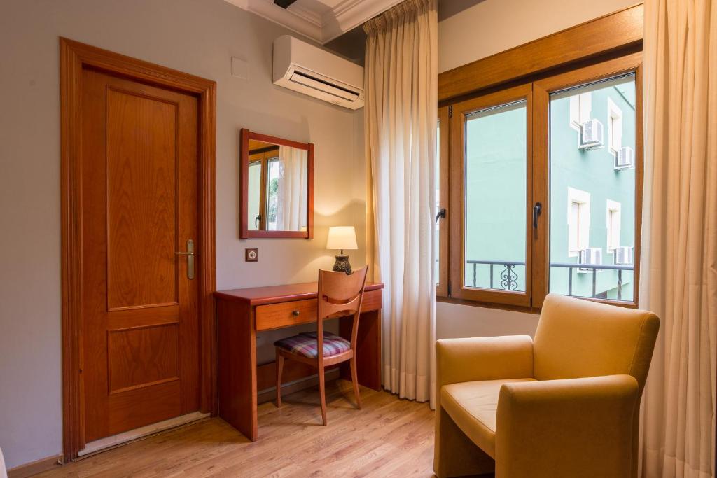 a room with a desk and a chair and a window at BYPILLOW California in Málaga