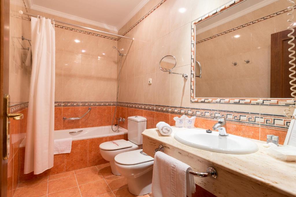 a bathroom with a toilet and a sink and a mirror at BYPILLOW California in Málaga