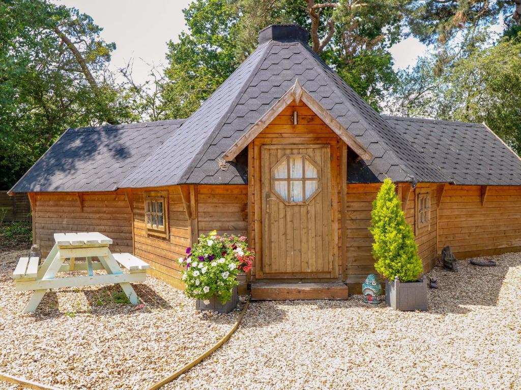 a small wooden cabin with a pitched roof at Enchanted Cottage in Snettisham