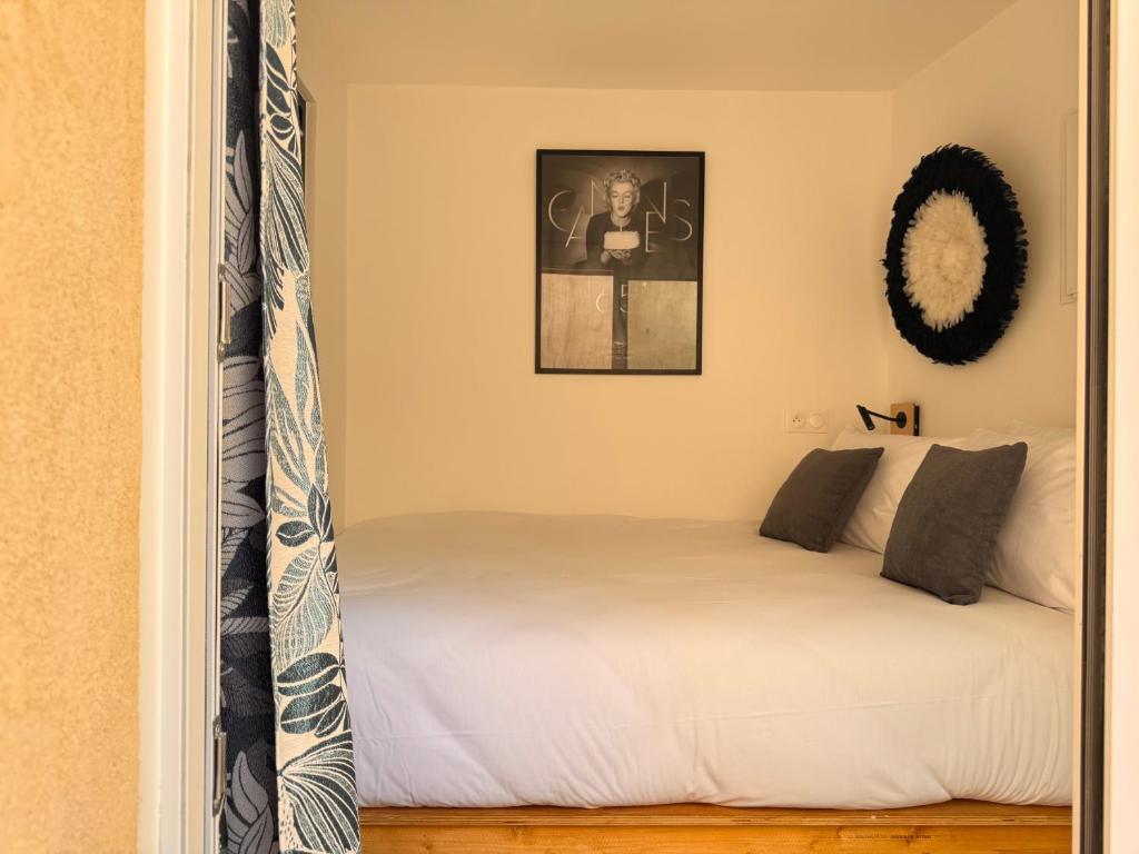 une chambre avec un lit et un tableau au mur dans l'établissement CB Cannes- NEW YORK, à Cannes