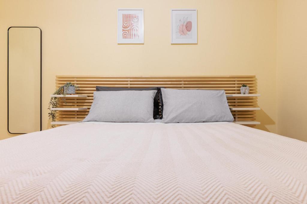 a bedroom with a white bed with two pillows at Centaurus Apartment in Old Town with a big Terrace ! in Thessaloniki