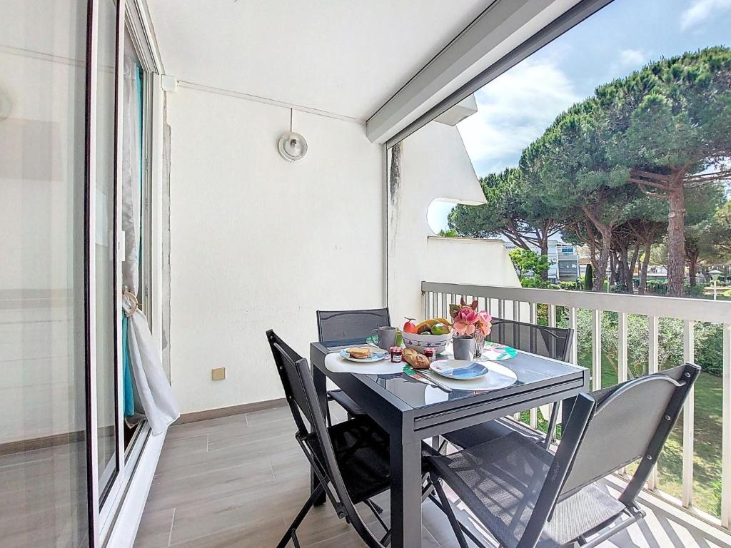 d'un balcon avec une table et des chaises. dans l'établissement Studio La Frégate-9 by Interhome, au Grau-du-Roi