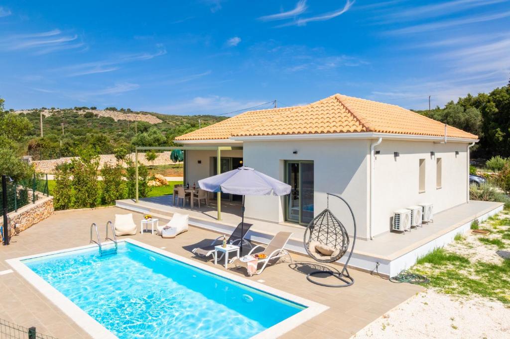 a villa with a swimming pool and a house at Villa Tania Ena in Karavádhos