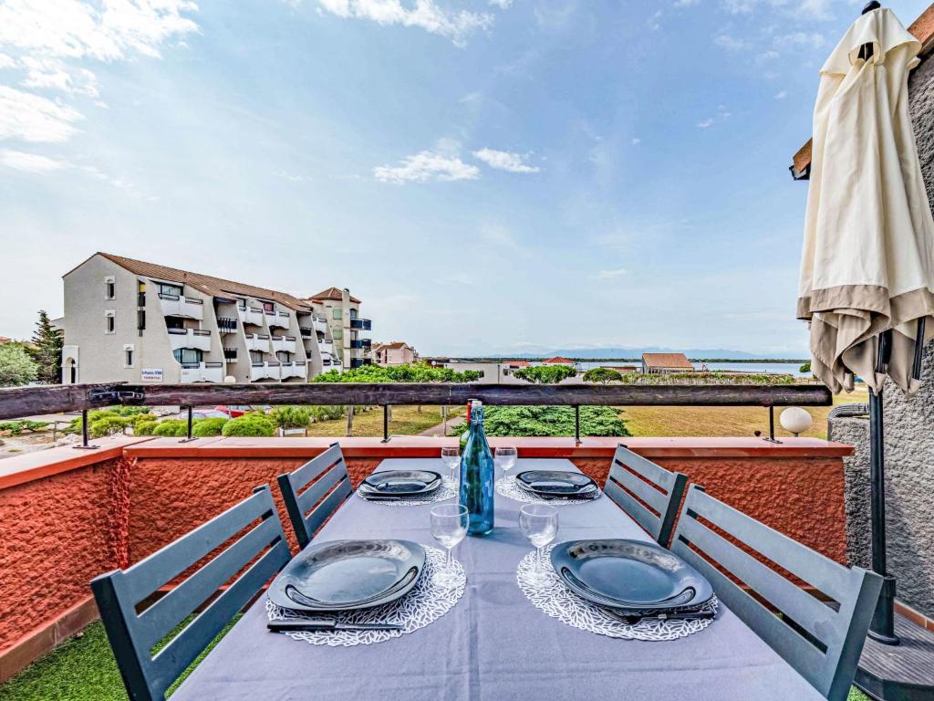 une table avec des assiettes et des serviettes sur un balcon dans l'établissement Apartment Sombrero-1 by Interhome, au Barcarès