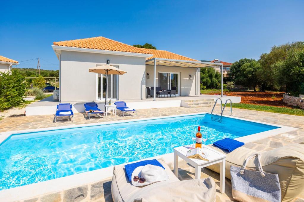 a villa with a swimming pool in front of a house at Villa Tania Dio in Karavádhos