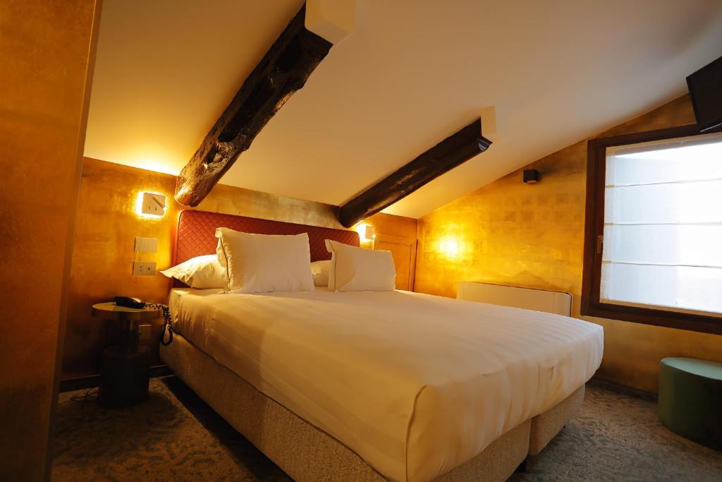a bedroom with a large white bed with a window at Ai Due Fanali Adults Only in Venice