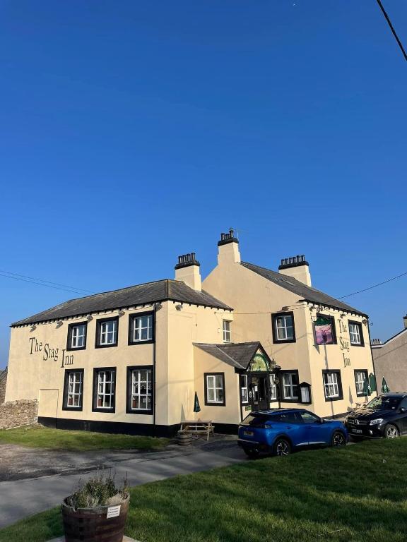 a building with a car parked in front of it at Room with Newly Renovated Private Bathroom above Village Pub Stag Inn Crosby Maryport in Maryport