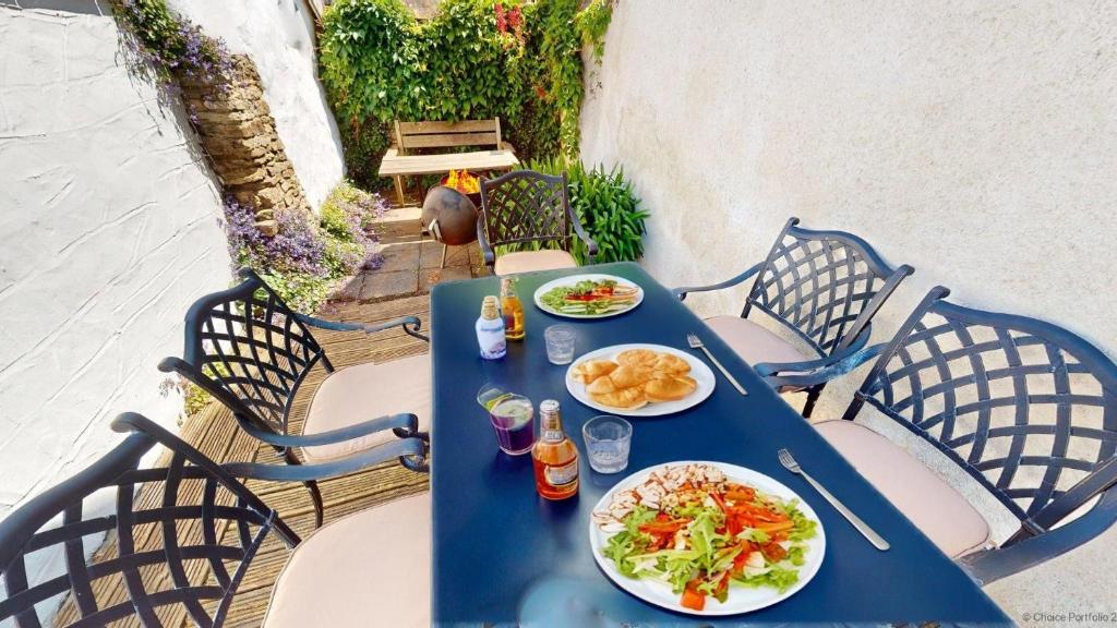 un tavolo blu con piatti di cibo sopra di Croyde Manor Mews 2 Bedrooms a Croyde