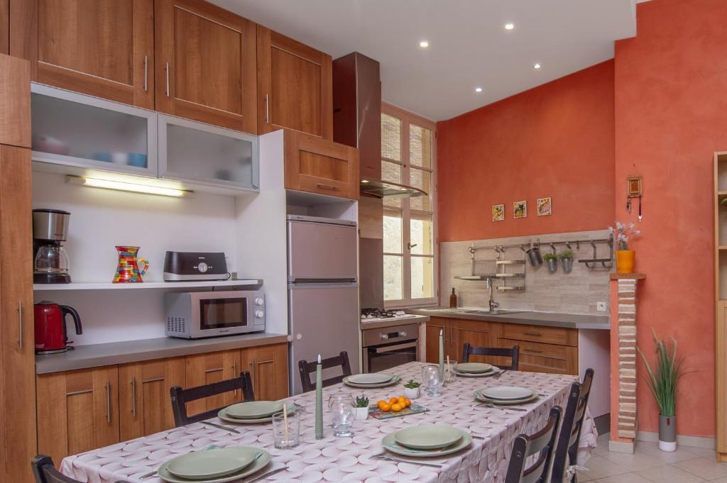une cuisine avec une table avec des chaises et un micro-ondes dans l'établissement Grand appartement dans la vieille ville, à Menton