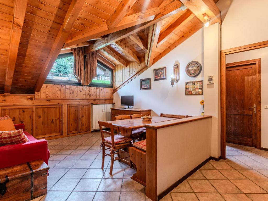 a dining room with a wooden table and a desk at Apartment Deliziosa Mansarda by Interhome in Ponte di Legno