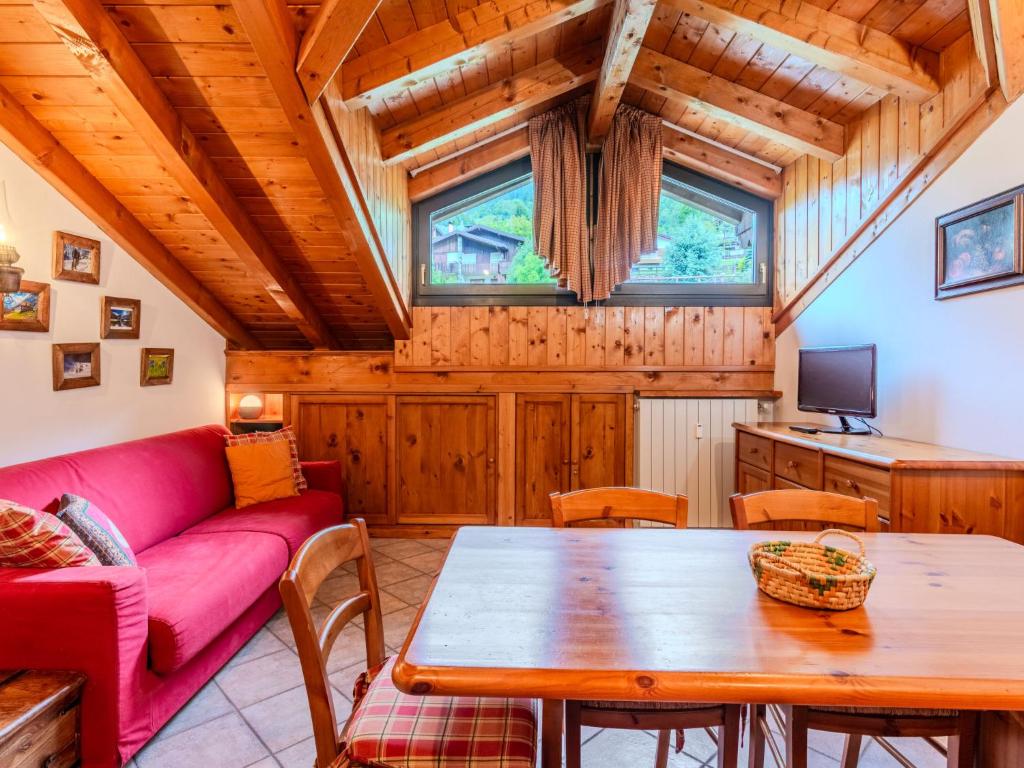 a living room with a red couch and a table at Apartment Deliziosa Mansarda by Interhome in Ponte di Legno