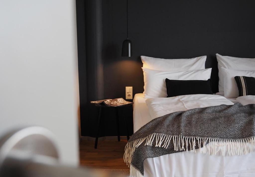 a bedroom with a bed with white sheets and pillows at Bold Hotel München Giesing in Munich
