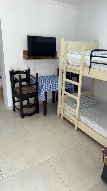 a room with a table and a chair and bunk beds at Dhoma Pushimi Tale Beach in Lezhë