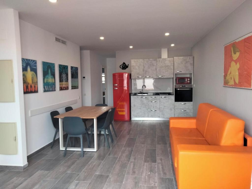 a living room with a table and a red refrigerator at Apartamentos Turísticos Tenor by Bossh! Hotels in Barcelona