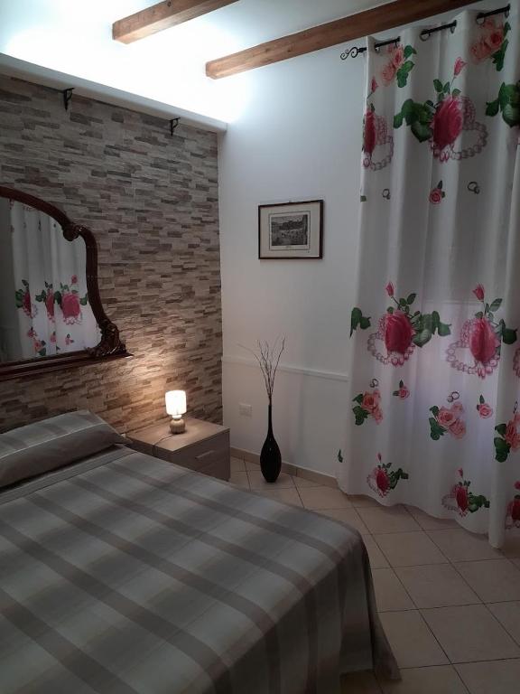 a bedroom with a bed and a window with flowers at CasaVacanzeLucia1 0 in Marsala