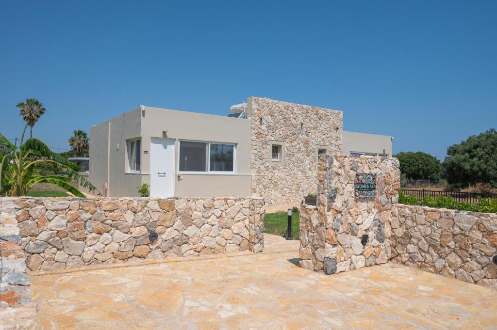 a stone wall with a house behind it at Stone and Sea Kos Oasis in Kos Town