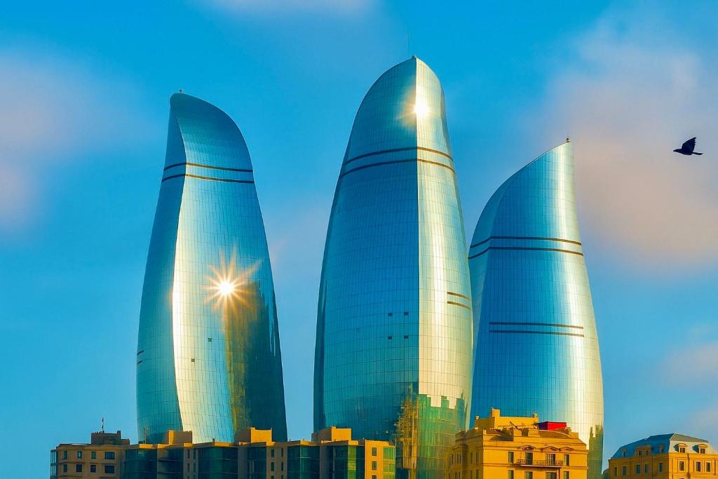 three tall skyscrapers in front of a city at SHAH INN Panoramic Apartments Old City F1 Track Принимаем карты МИР in Baku