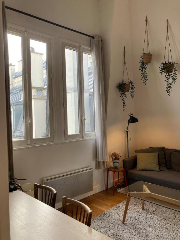 un salon avec un canapé et une table dans l'établissement Joli appartement dans le centre de Paris, à Paris