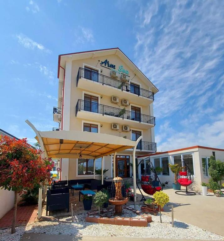 a building with a large umbrella in front of it at Armsea Mamaia Nord in Mamaia Sat/Năvodari