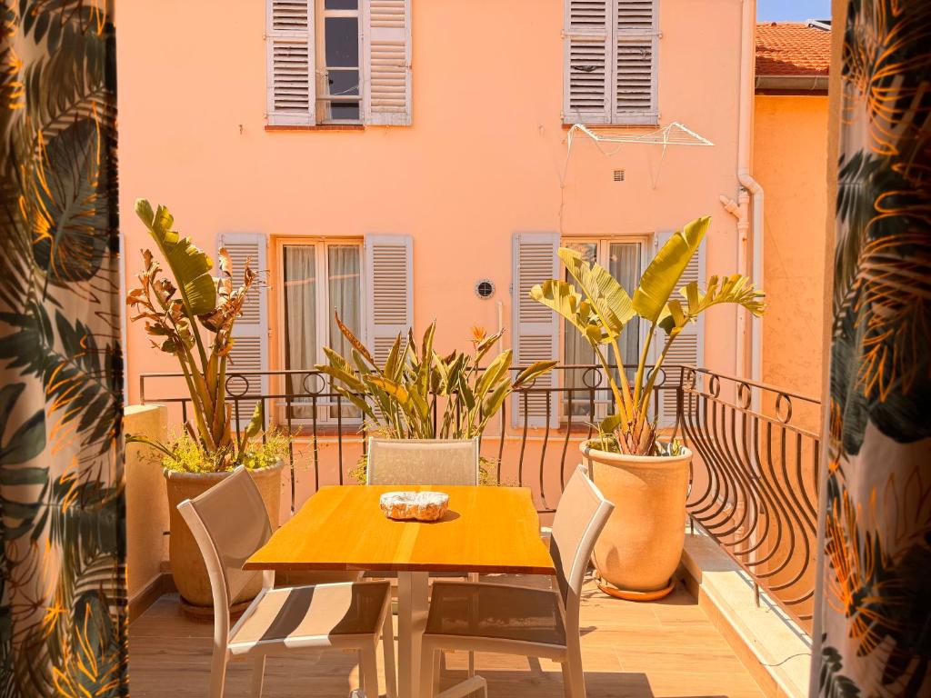 d'une table et de chaises sur un balcon orné de plantes. dans l'établissement CB Cannes - JUNGLE, à Cannes