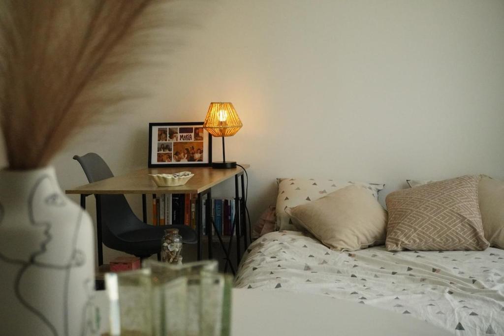 une chambre avec un lit et une table avec une lampe dans l'établissement Logement neuf - cœur de ville, à La Roche-sur-Yon