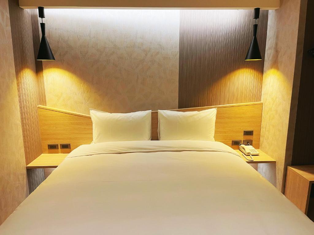 Postel nebo postele na pokoji v ubytování 新仕飯店-New City Hotel