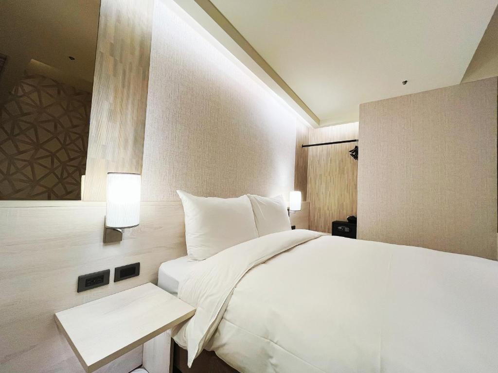 Postel nebo postele na pokoji v ubytování 新仕飯店-New City Hotel