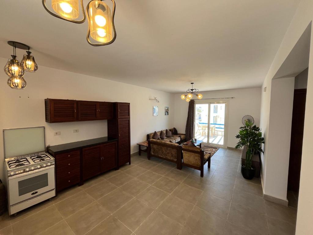 a kitchen and living room with a stove and a couch at Amazing 3 Bedrooms Penthouse MountainView Northcoast - Ras Elhekma in Ras Elhekma