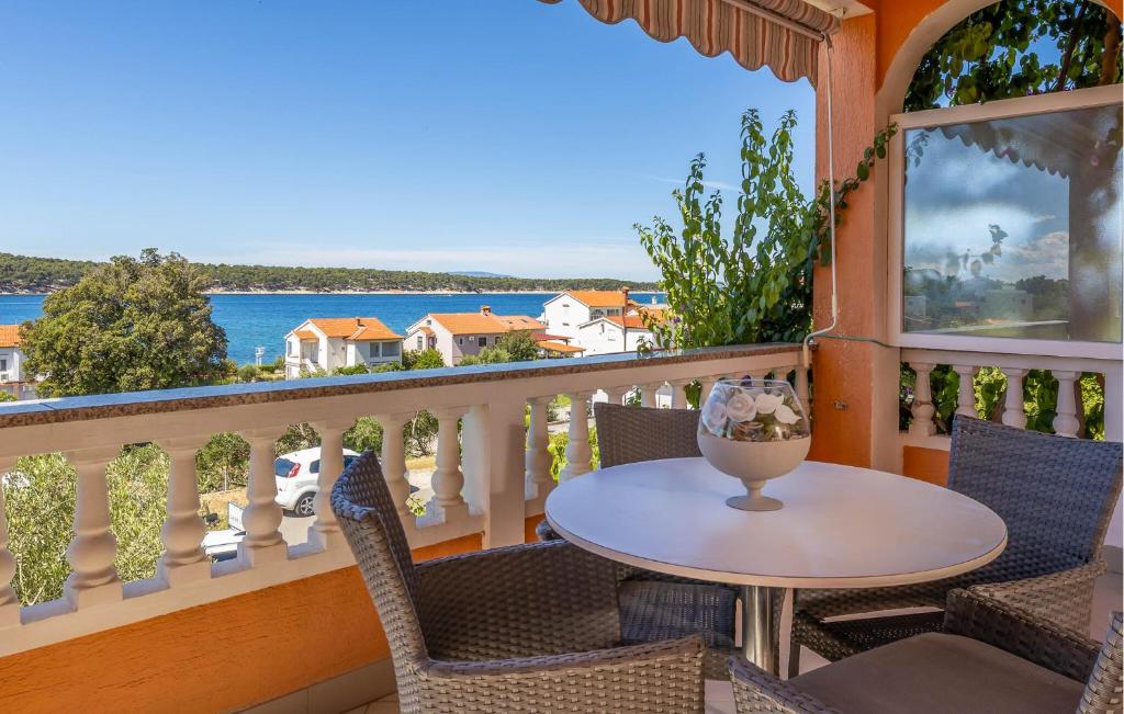 a balcony with a table and chairs and a view of the ocean at Lovely Apartment In Barbat Na Rabu in Barbat na Rabu