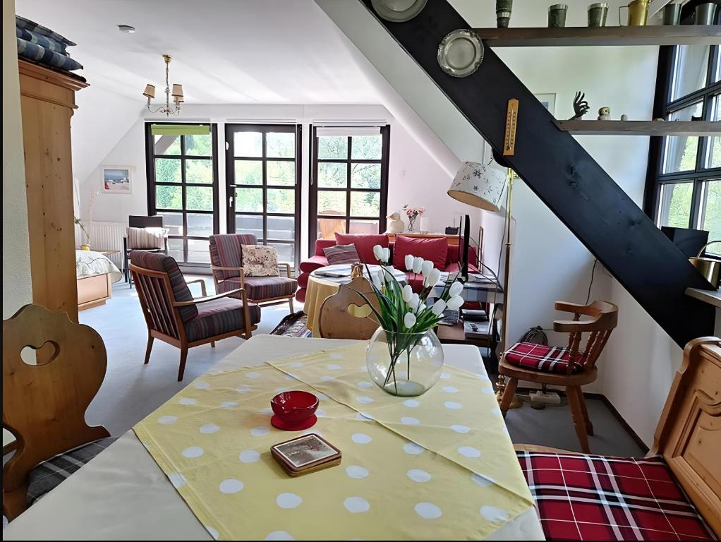 a living room with a table with a vase of flowers on it at Ferienwohnung Königswinter in Königswinter