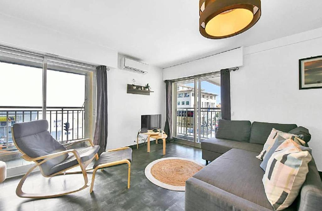 un salon avec un canapé et une chaise dans l'établissement LE VERSAILLES plaisir et confort en centre-ville, pour séjours en famille ou business, à Cannes