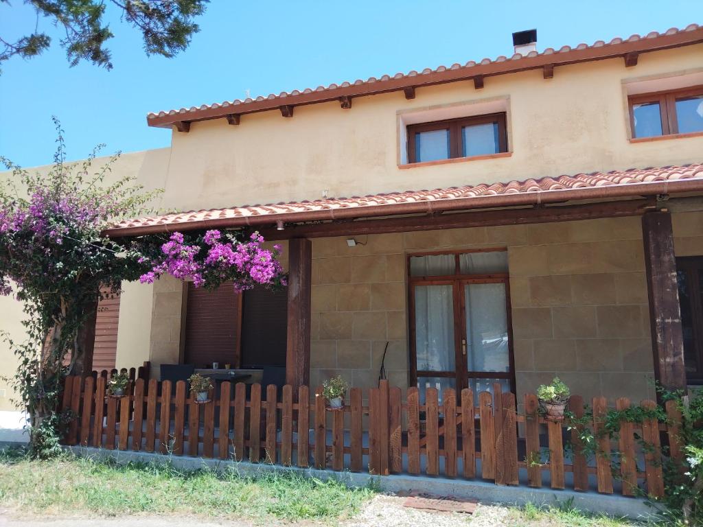 una casa con recinzione e fiori viola di EL MATORRAL ad Alghero