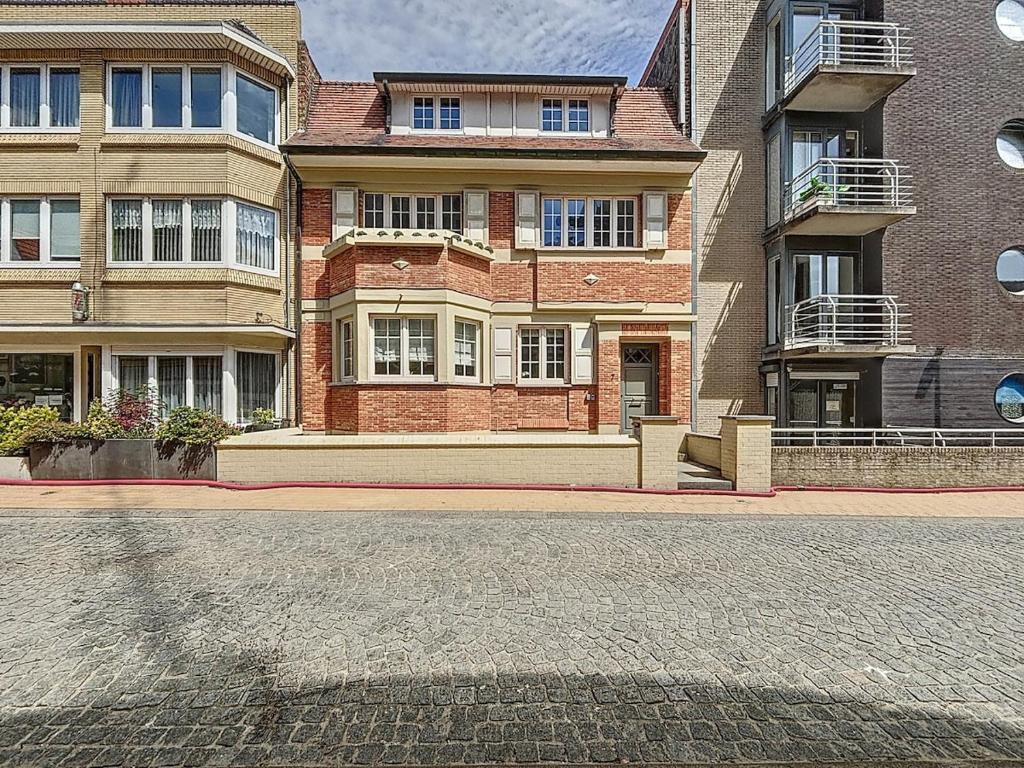 a large brick building on a city street at Maison 't Blyhuis in De Panne in De Panne