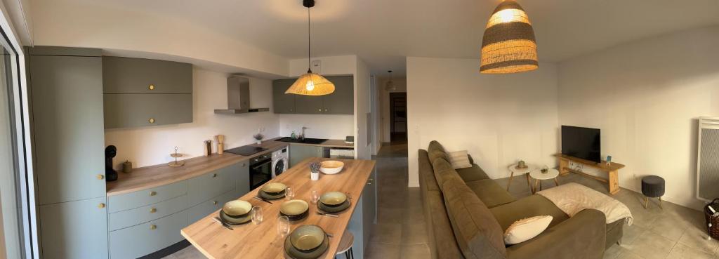 une cuisine et un salon avec une table et un canapé dans l'établissement Joli 3 pièces à la plage Sud de Vieux-Boucau, à Vieux-Boucau-les-Bains