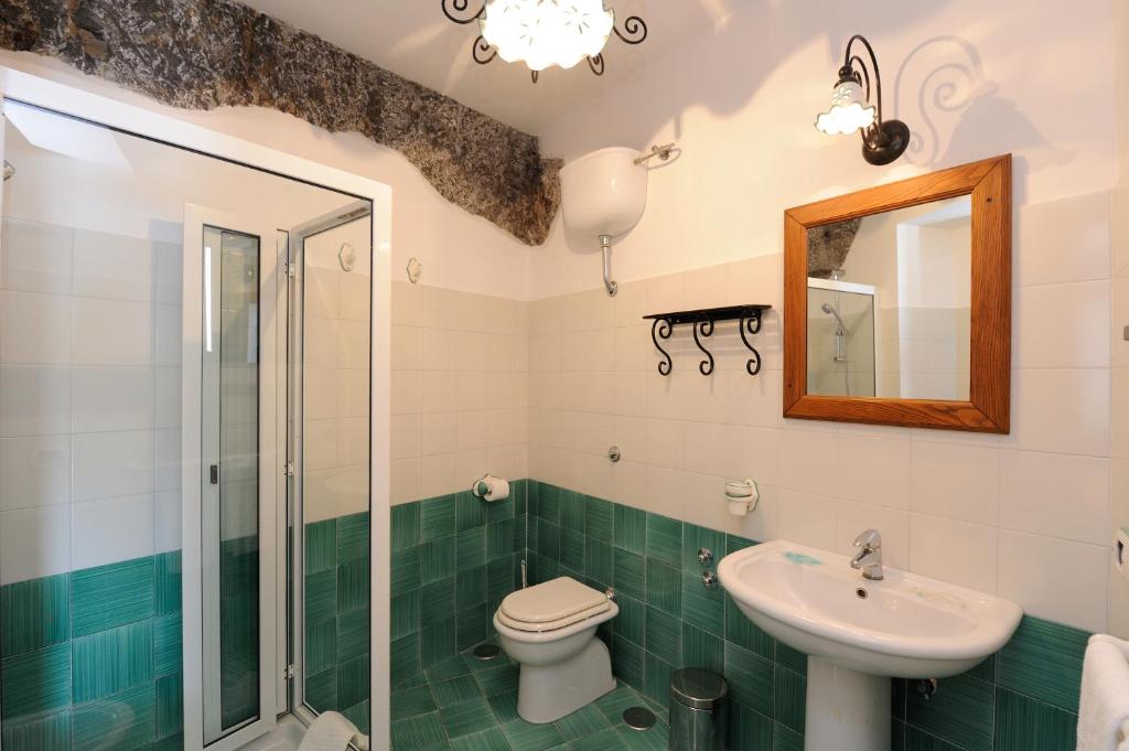 W łazience znajduje się toaleta, umywalka i lustro. w obiekcie La Casa Del Melograno w mieście Furore