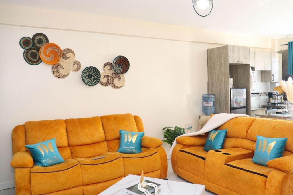 1 sofá naranja y 2 sillas en la sala de estar. en Lexus Homes, en Nakuru