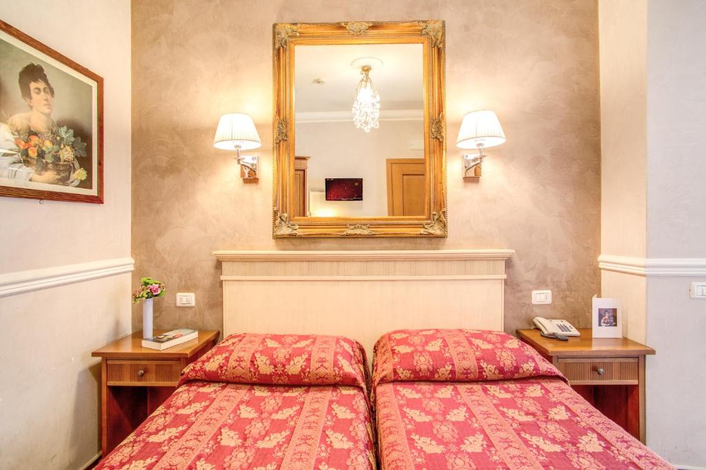 a bedroom with a bed and a mirror at Hotel Caravaggio in Rome