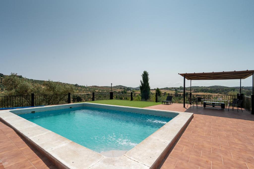 una piscina con tavolo e un padiglione di Cortijo señora de las Angustias 1 ad Alanís