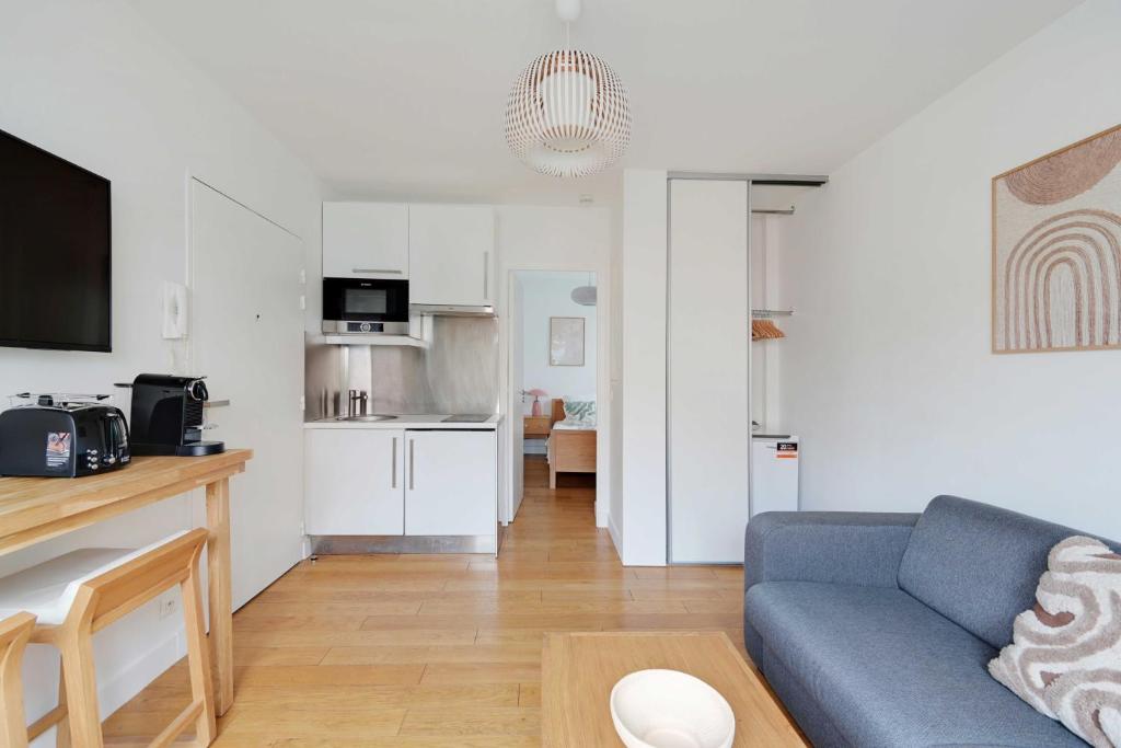 un salon avec un canapé bleu et une cuisine dans l'établissement Charming apartment - 1BR-4P- Suresnes, à Suresnes