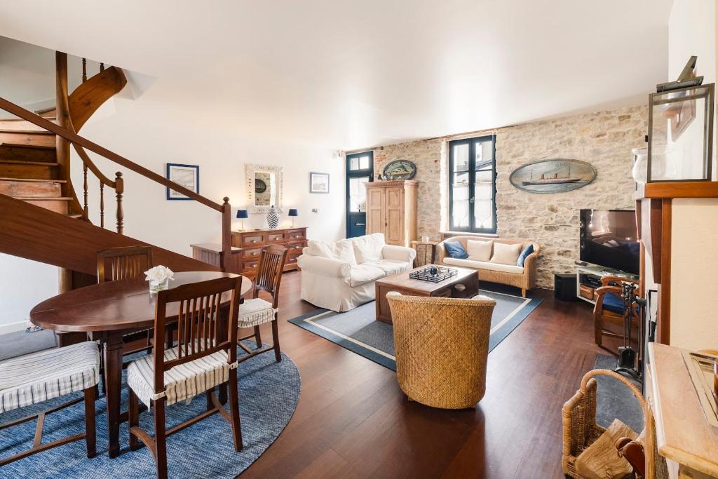 - un salon avec un escalier, une table et des chaises dans l'établissement Maison charme tout à pied coeur Pouliguen, au Pouliguen