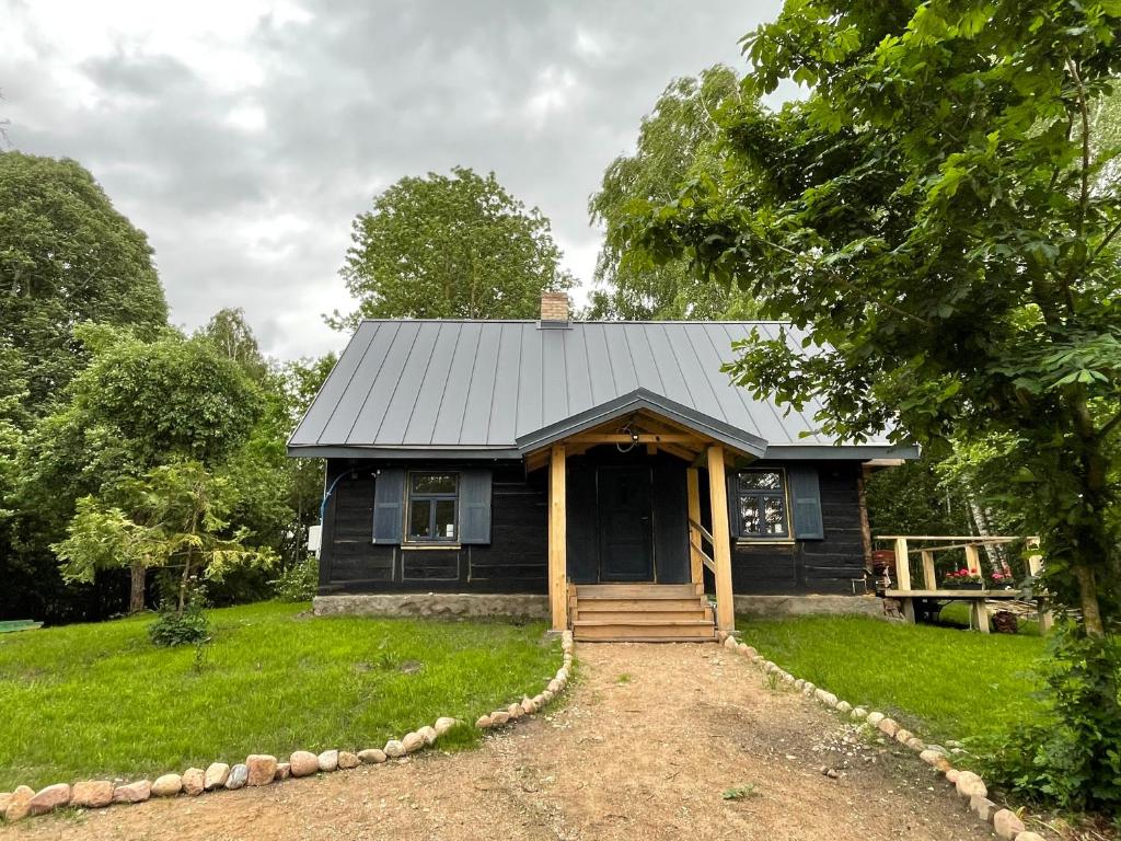 a small black house with a porch at Leonówka in Jegliniec