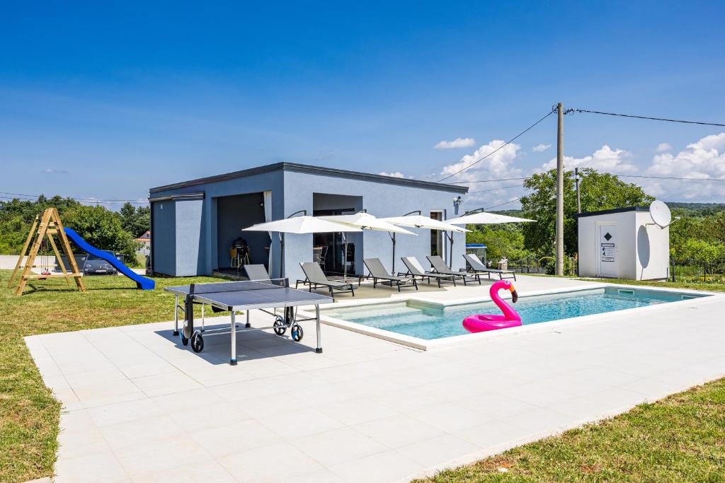 a house with a swimming pool and a playground at Villa Hera with Private Pool in Istria Quiet Location and Modern Design in Orbanići