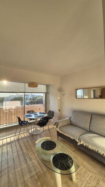 un salon avec un canapé, une table et des chaises dans l'établissement Port de Hyères appartement 4 personnes et parking, à Hyères
