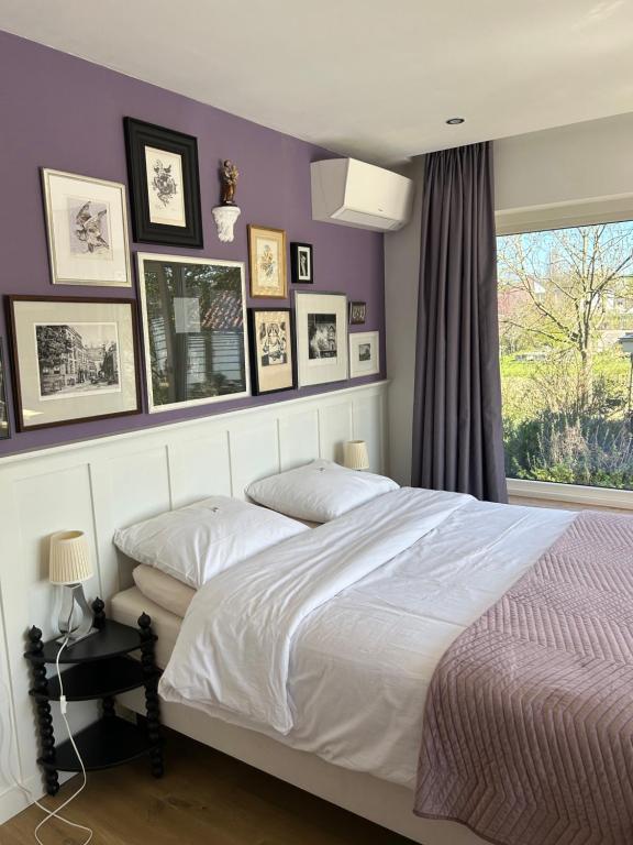a bedroom with a white bed and pictures on the wall at Boutiquehotel B&B the SJinn in Schin op Geul