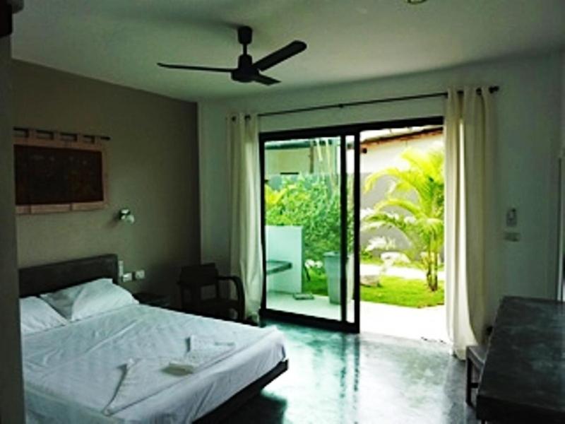 Sairee Sairee Guesthouse في كو تاو: غرفة نوم بسرير ومروحة سقف