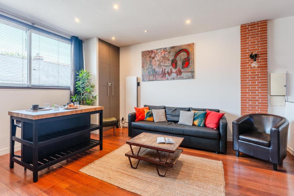 un salon avec un canapé et une table dans l'établissement Loft Lamoricière - 15 minutes à pieds du centre, à Nantes