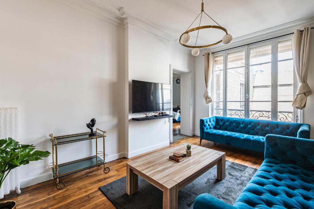 un salon avec un canapé bleu et une table dans l'établissement The Jeanne d'Arc - Center - Cathedral, à Reims