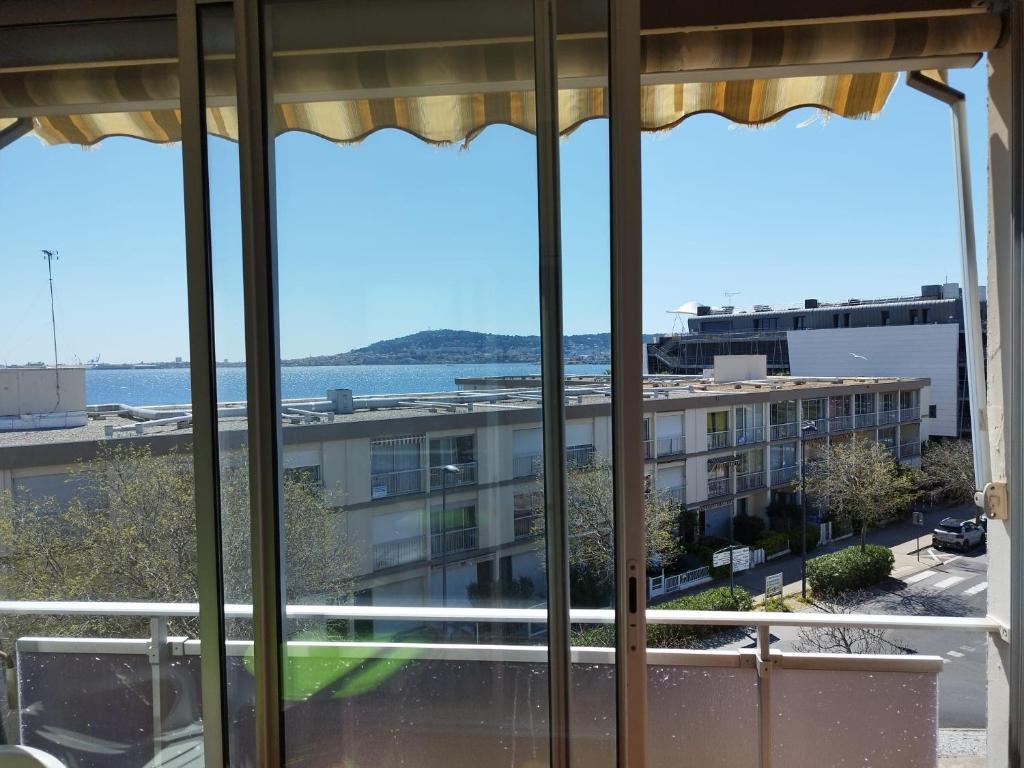 una vista de un edificio desde una ventana en Studio cosy avec vue exceptionnelle sur l'étang de Thau, en Balaruc-les-Bains